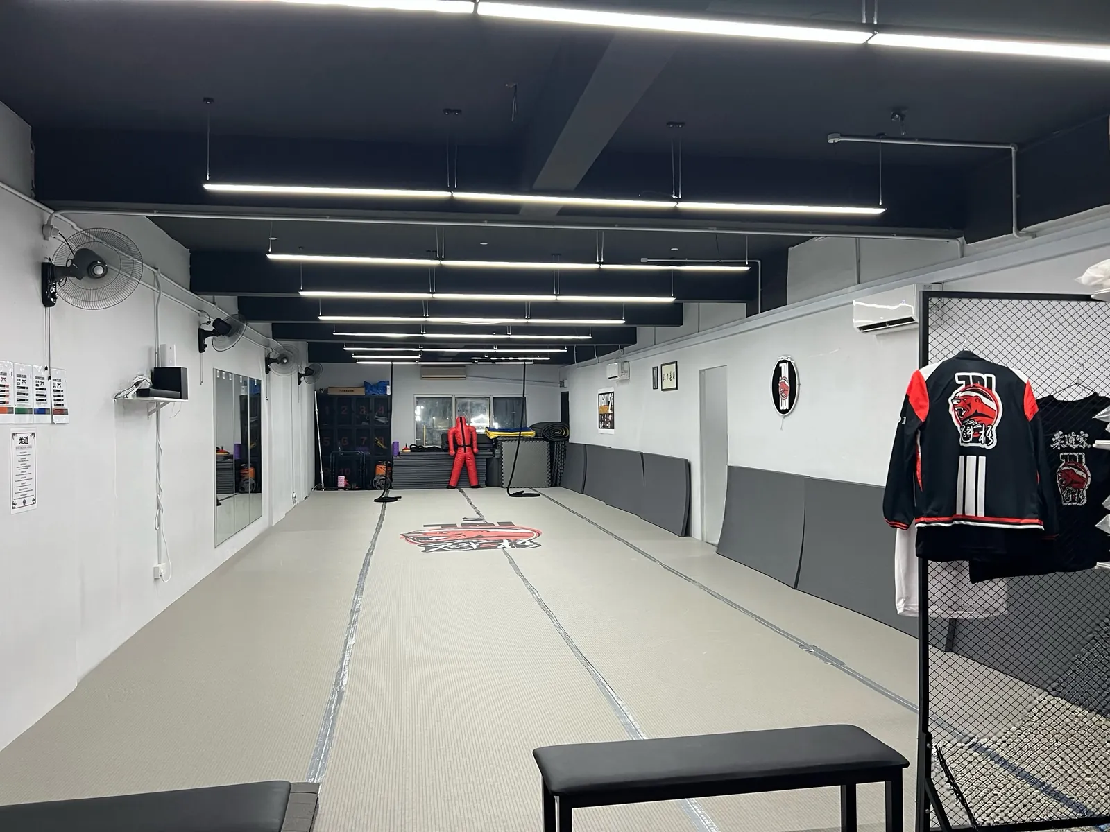 View down the full length of the dojo from the entrance, with the team jacket on the rack
